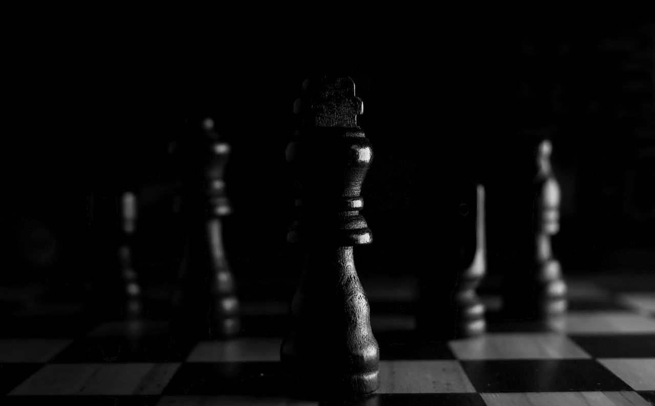 ours-journey Strategic close-up of chess pieces on a board, highlighting the queen in black and white.